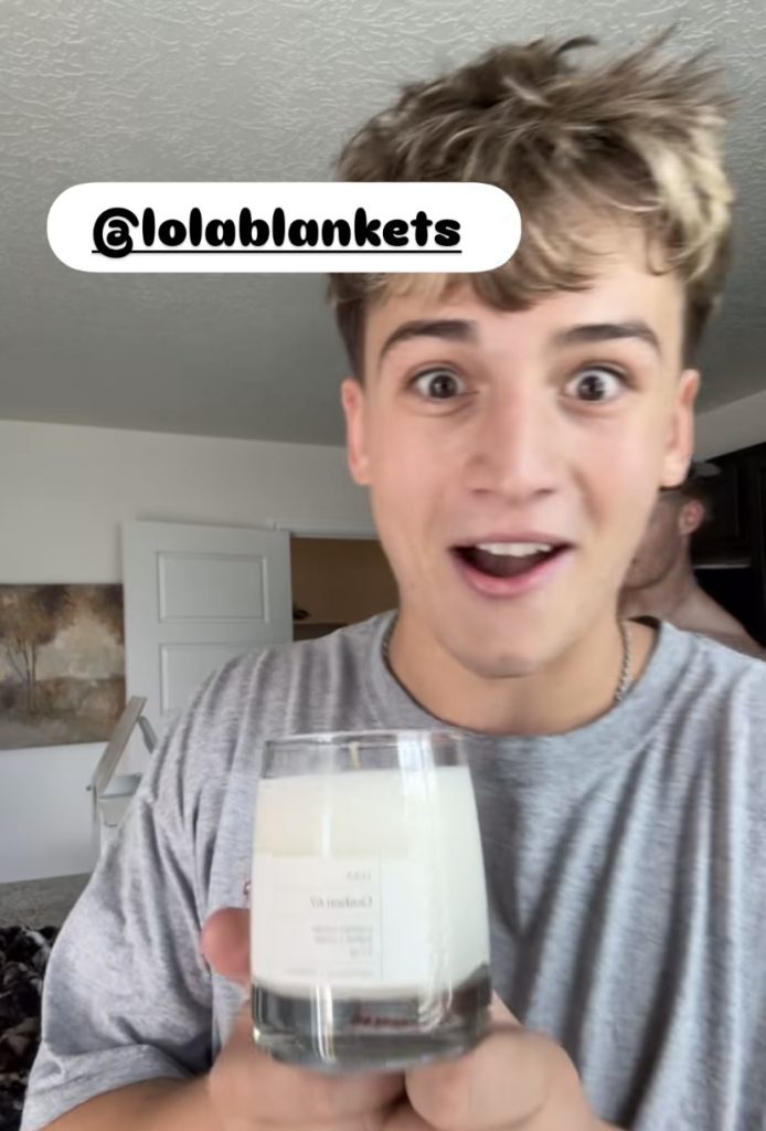 Spencer showcases his new candle he received from LolaBlankets,